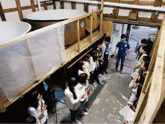 Students visiting a traditional sake brewery and learning about the local industry from a craftsman.